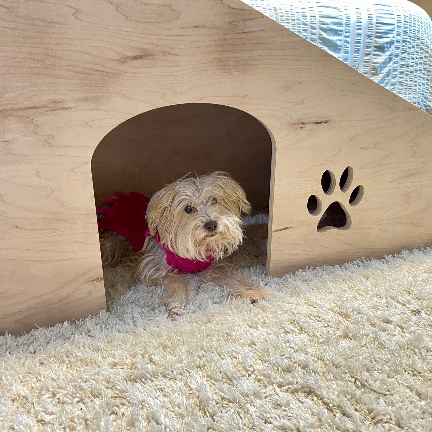 Image showing a dog happily laying inside the doggie door beneath our 20-inch pet ramp with platform, providing easy access and convenience for pets to move between spaces.