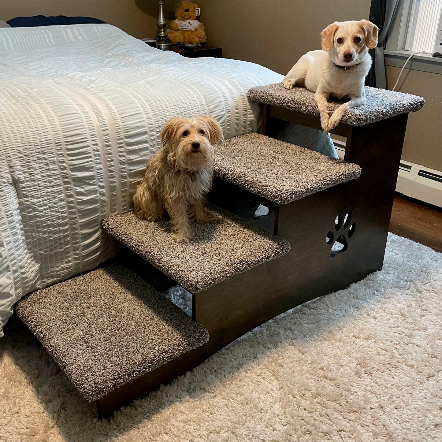 Image featuring two dogs sitting comfortably on the steps of our extra deep 23-inch pet steps in ebony stain with apollo blue carpeting, highlighting the product's size, color, and carpet option against a neutral background.